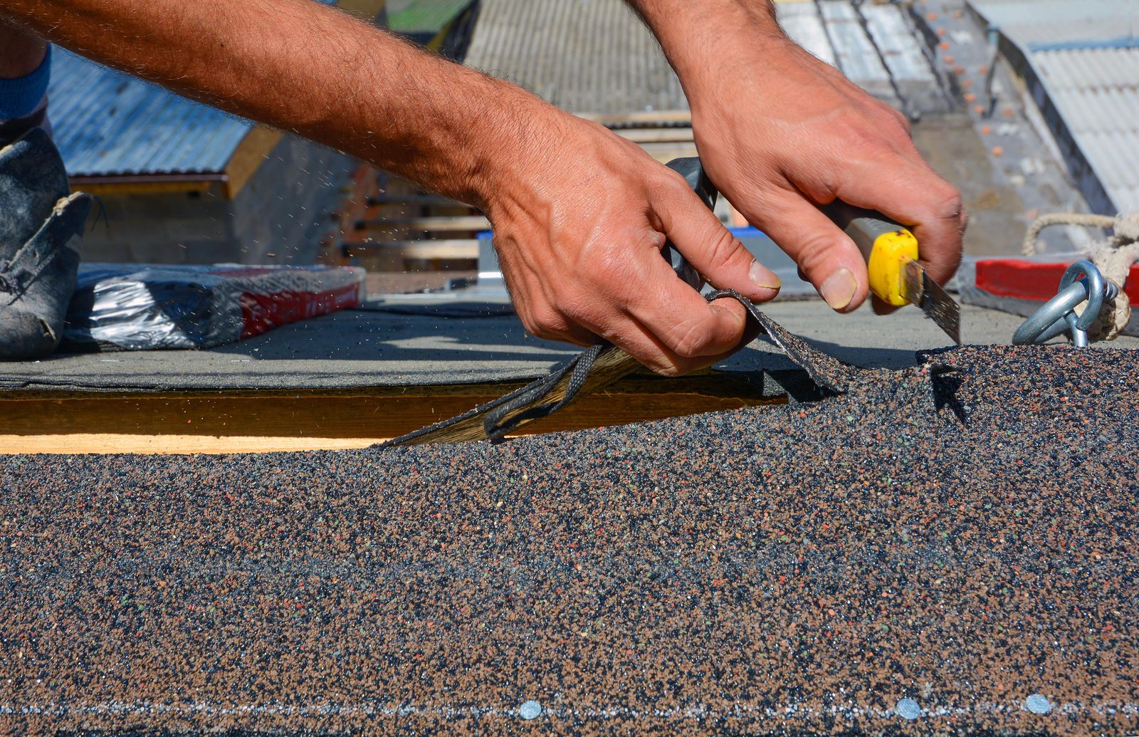 Tomas cutting shingles at the ridge on a Hoffman Estates two-story